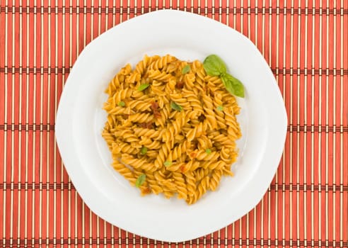 Italian pasta, fusilli, with tomato sauce and basil.