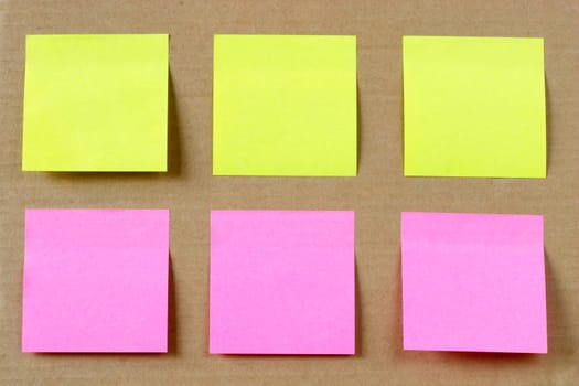 Six colored (yellow and pink) notes on cardboard