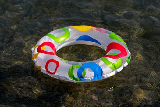 Inflatable ring floating on the sea, transparent clear water