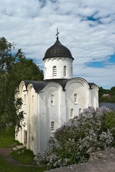 White stone russian church with blossoming lilac