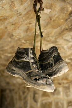 Construction worker left his aged old boots away, hunged on the rocks