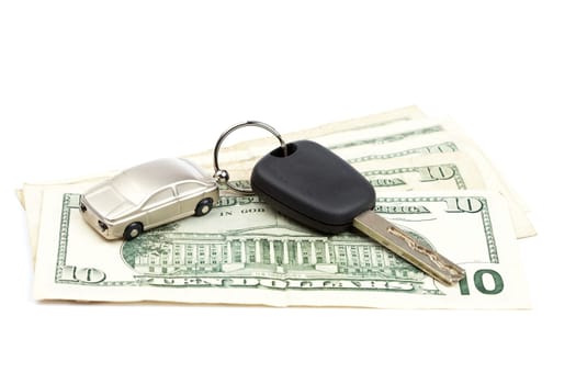 Car key and dollar bills on white background with shallow depth of field