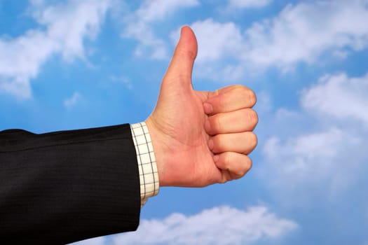 Thumb up gesture over sky and clouds backgound