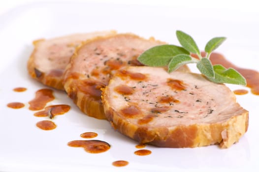 Three slice of roasted meat with sage and garnish