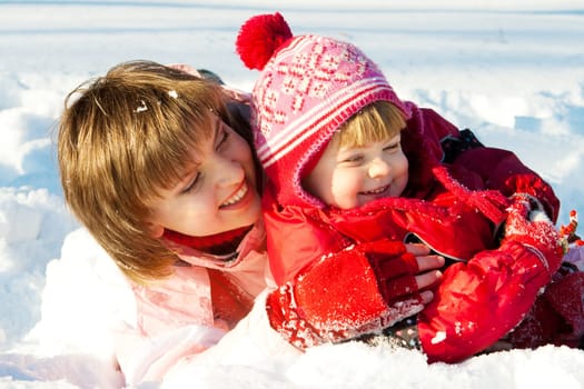 Mother and daughter playing in the snow