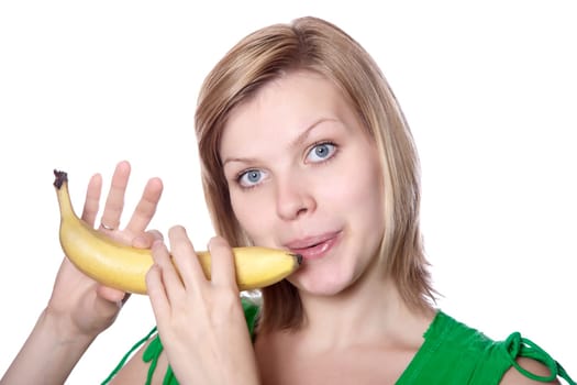beautiful blonde young girl playing on a banana like a flute, isolated on white