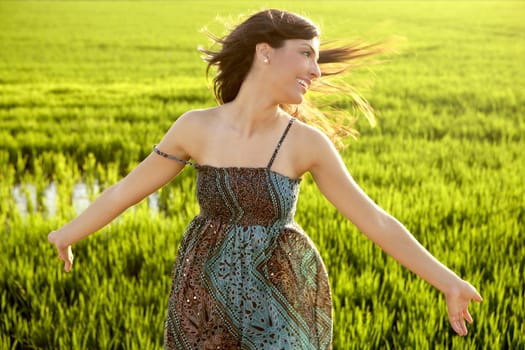 Beautiful brunette indian young woman in the green rice fields meadow
