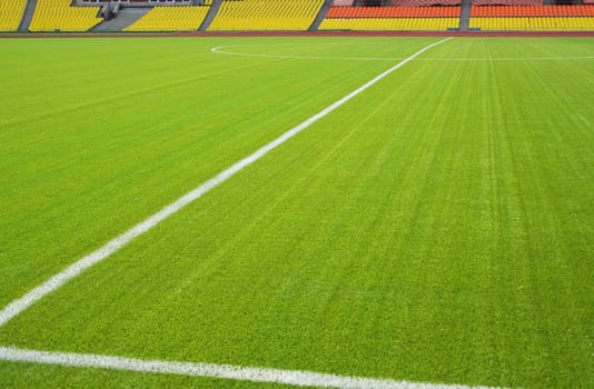 View of the green grassy artificial lawn on football/soccer field