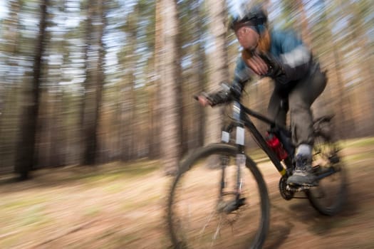 Woman-biker blurred in motion. Cross-country.