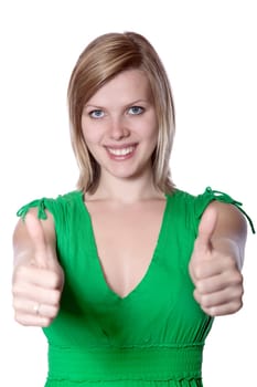 Joyful young woman in a green dress gives thumbs up