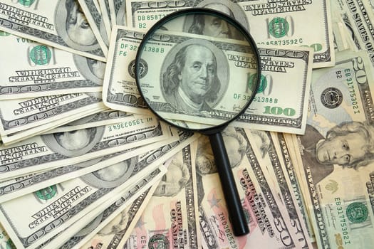 photography of the dollars with magnifying glass
