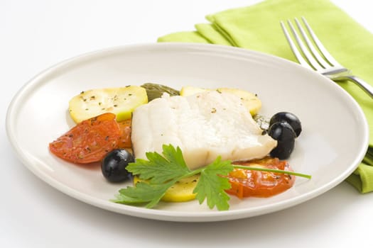 fillet of cod baked tomatoes zucchini black olives isolated