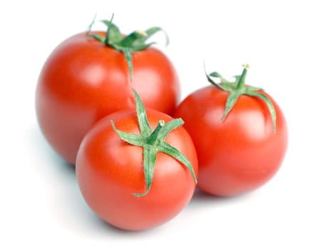 three fresh raw tomattos over white