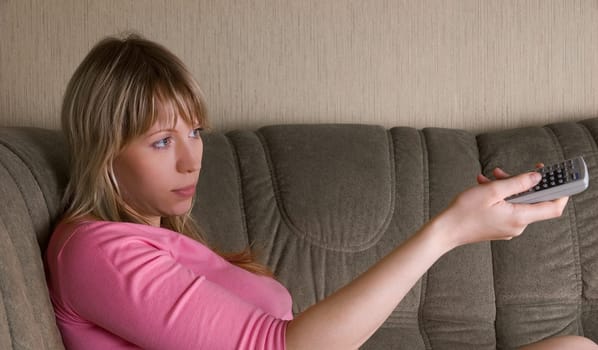Girl sitting on the sofa and watching tv