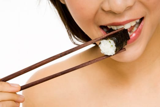 A young woman bites into a sushi roll