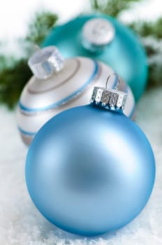 Closeup of three Christmas decorations sitting in snow