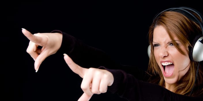 portrait of young woman enjoying music and pointing aside