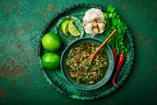 Raw homemade Argentinian green Chimichurri or Chimmichurri salsa or sauce made of parsley, cilantro, chili, garlic, oregano, olive oil and red wine vinegar