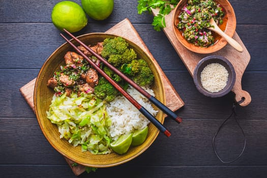 Chicken bowl with rice, broccoli, cabbage and green Chimmichurri salsa