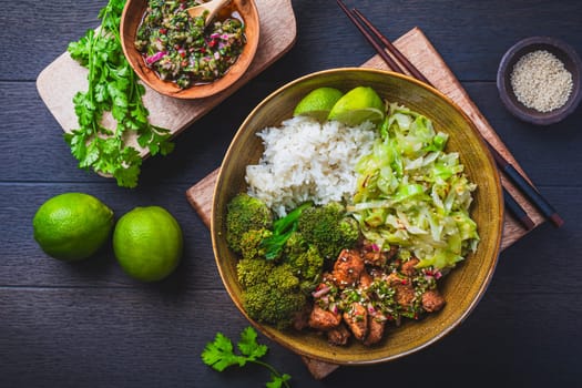 Chicken bowl with rice, broccoli, cabbage and green Chimmichurri salsa