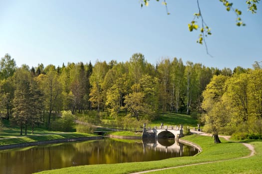 Old classical bridge amongst picturesque spring nature in park