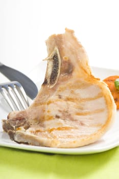 tasty pork chop with corn carrot tomato isolated