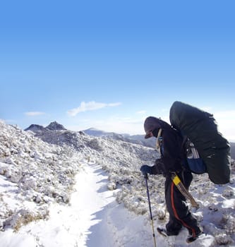 There was a backpacker with heavy pack walk on the snow.