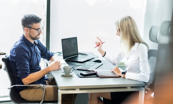 Business meeting. Client consulting. Confident business woman, real estate agent, financial advisor explaining details of project or financial product to client in office