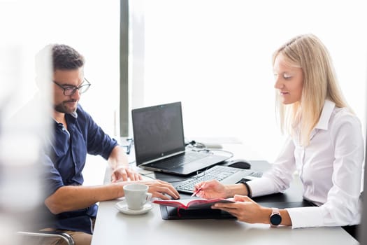 Business meeting. Client consulting. Confident business woman, real estate agent, financial advisor explaining details of project or financial product to client in office