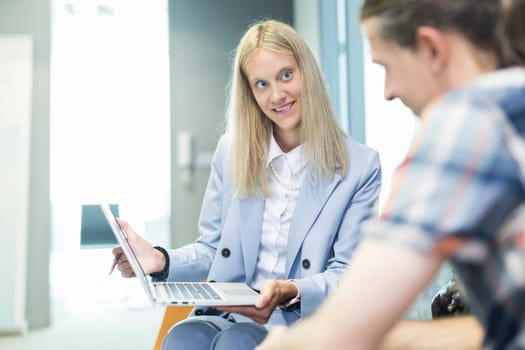 Business meeting. Client consulting. Confident business woman, real estate agent, financial advisor explaining details of project or financial product to client in office