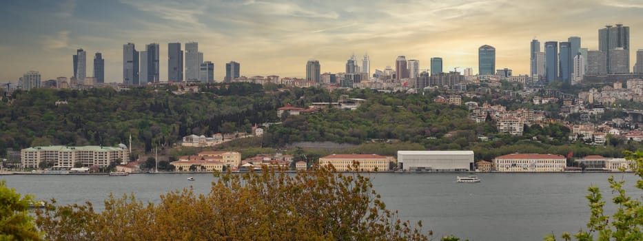 Aerial panoramic view from Fethi Pasha Grove overlooking Bosphorus and European side of Istanbul, Turkey at sunset, with green mountains and modern tall buildings