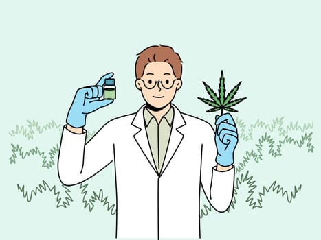 Man biologist with cannabis oil, produced from petals of narcotic plant, recommending legalization of marijuana. Doctor in white coat demonstrates cannabis leaf that helps fight dangerous diseases