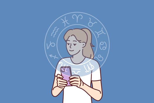 Woman reads astrological horoscope forecast on phone or finds out compatibility with zodiac signs. Horoscope wheel near girl with smartphone using mobile application with aracul predicting future
