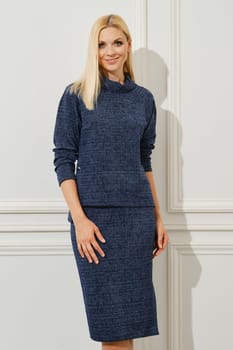 Cheerful woman in pale blue knit top and tight skirt