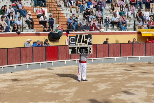March 26, 2023 Lisbon, Portugal: Tourada - man with a scoreplate on the arena. Mid shot