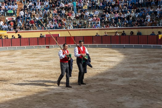 March 26, 2023 Lisbon, Portugal: Tourada - forcado walk along the arena holding spears. Mid shot