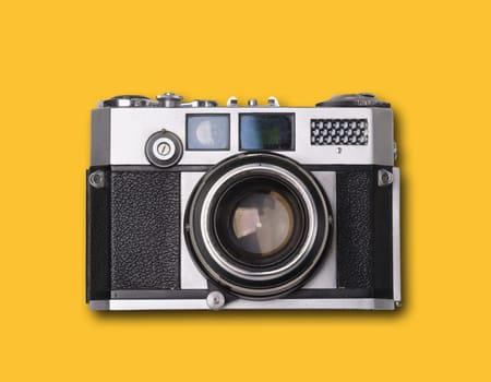 vintage old film camera on yellow background with shadow