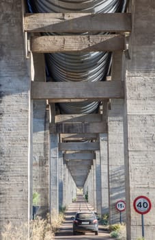 Vehicle crossing the road under Acedera Aqueduct, Vegas Altas del Guadiana, Badajoz, Extremadura, Spain