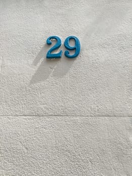 House number 29, blue painted iron over wall. Houses with personality concept