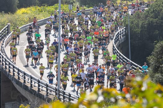 March 12, 2023 Lisbon, Portugal: people run a marathon on the bridge. Mid shot