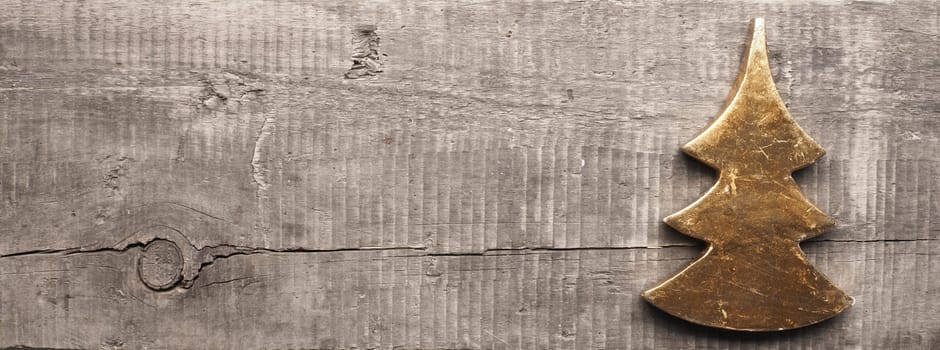 Golden Christmas tree shape on a rustic wooden plank with space for text