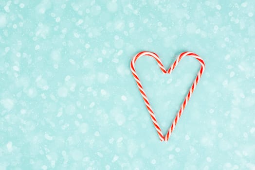 Candy cane forms heart shape, Christmas holiday background, winter season greeting card