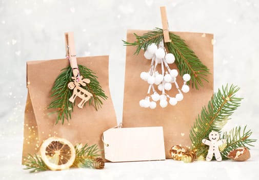 Christmas holiday gift bags for suprise, fir branches, gingerbread man, elk, snow covered berries and nuts, blank tag with copy space