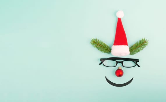 Face of a reindeer with a red bauble nose, fir antlers, a santa claus hat and eyeglasses, merry christmas greeting card
