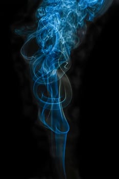 The steam color smoke of in movement on a black background. It is abstract.