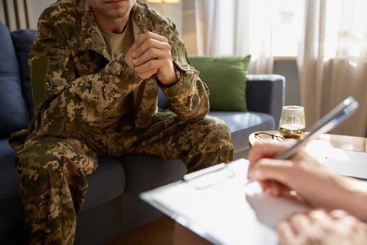 Closeup cropped shot of soldier visiting to psychologist for help and support. Mental health problem of military person treatment