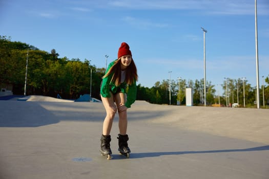 Teenager girl inline skating on boardwalk making stunt and tricks. Summer evening active leisure activity