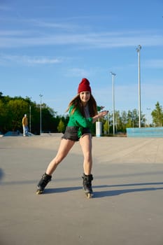 Healthy teenager girl enjoys rollerblading speed moves. Active rest and sport training in summer