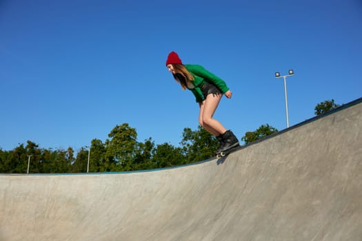 Teenager girl wearing roller blades enjoying extreme sports event. Youth culture, sport and hobby recreation