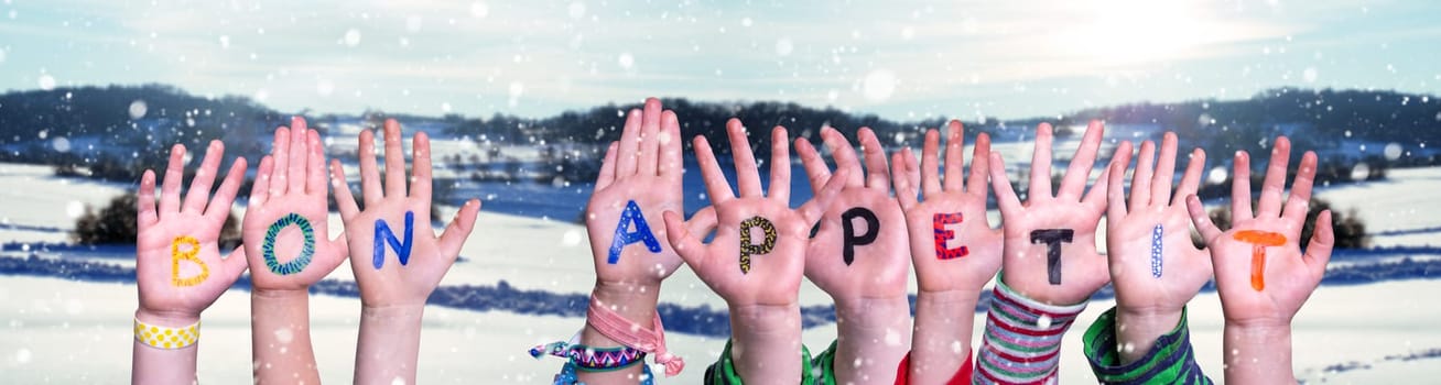 Children Hands Building Colorful Word Bon Appetit. White Winter Background With Snowflakes And Snowy Landscape.